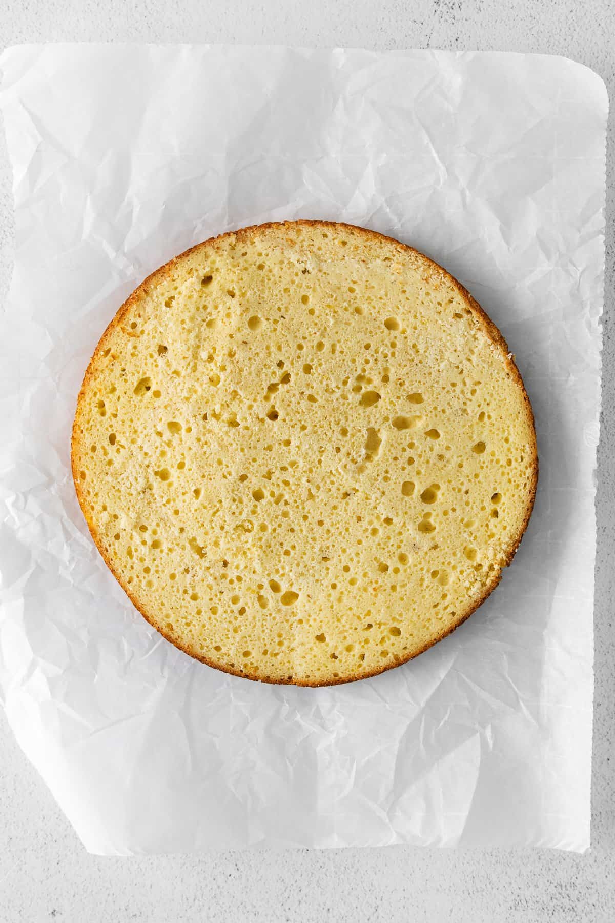 One half of a ricotta cake on parchment paper. 