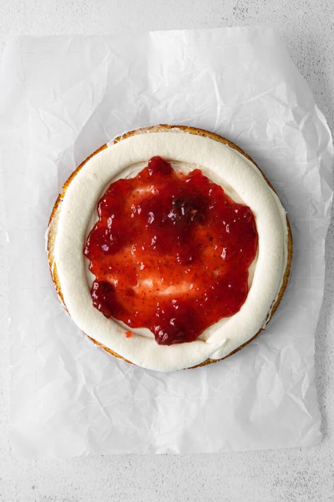 Strawberry preserves spread out on a layer of ricotta cake. 