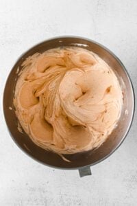 a bowl of orange icing on a white background.