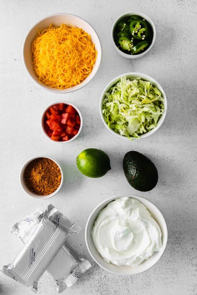 taco dip ingredients in bowls