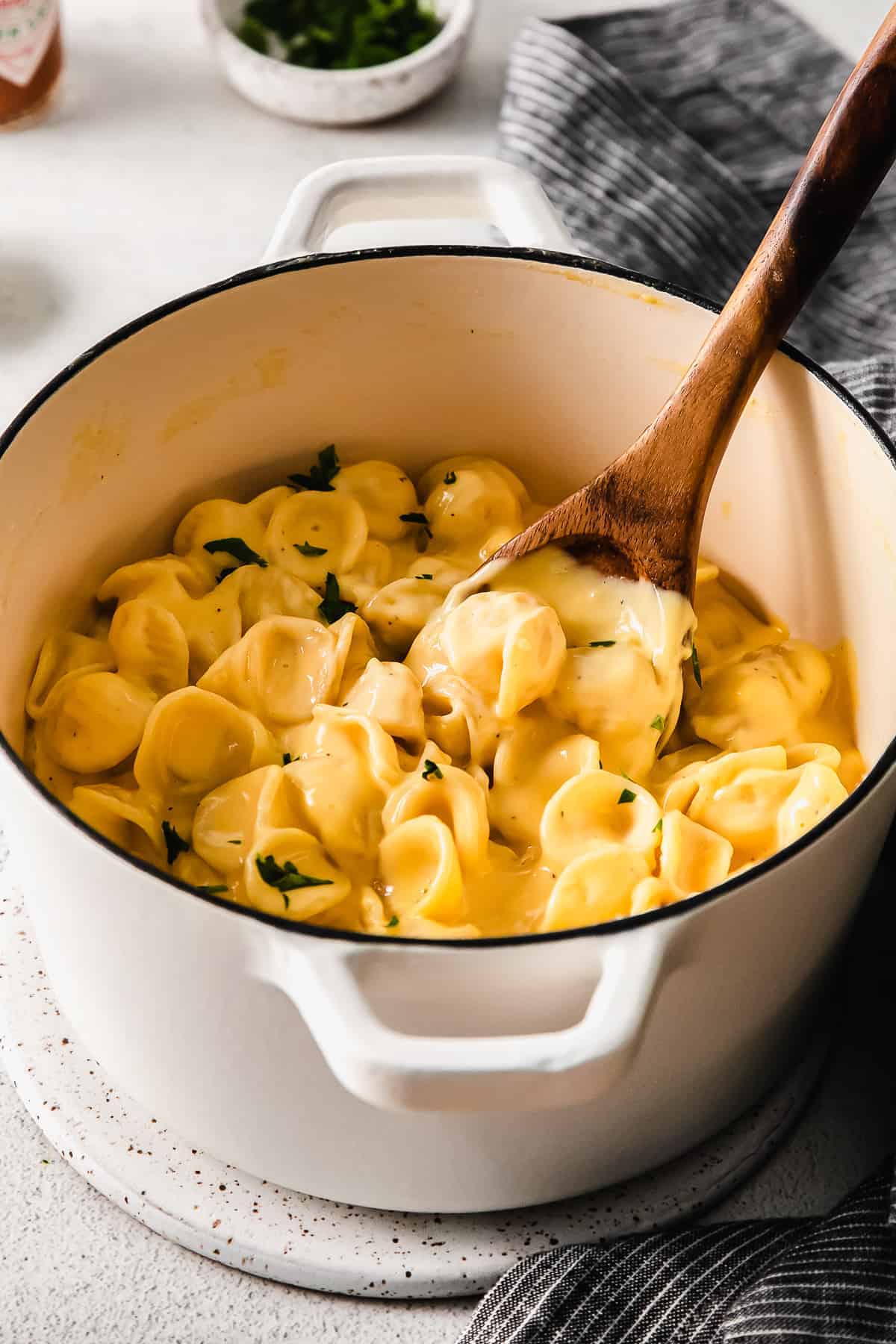 velveeta mac and cheese in a stock pot with a wooden spoon