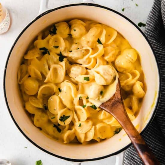 Creamy, velvety pasta cooked with a wooden spoon in a pot.