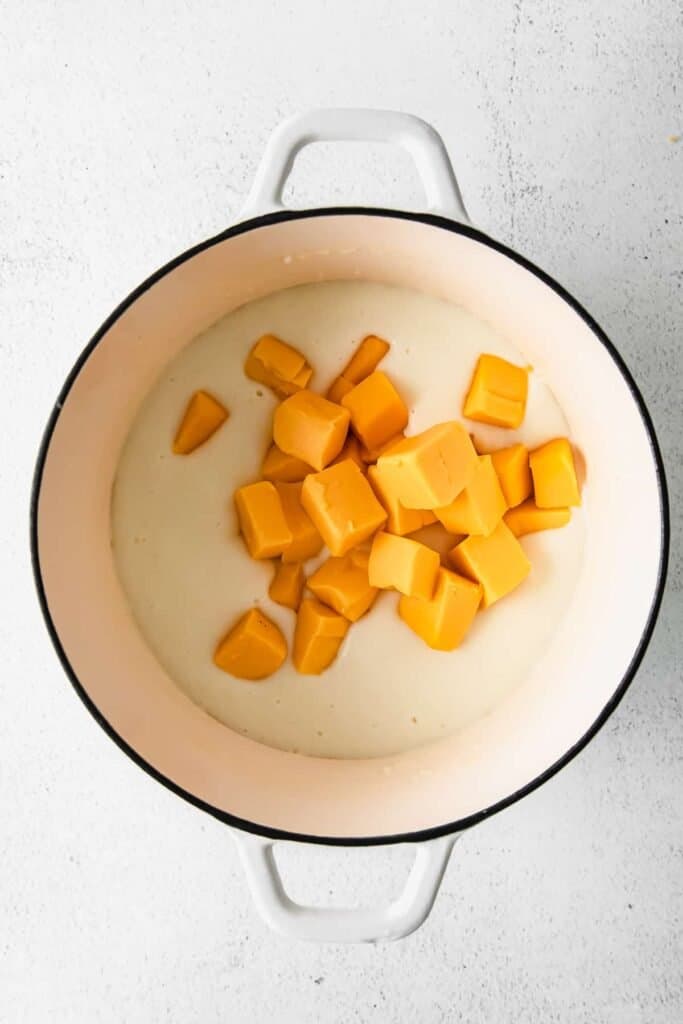 blocks of velveeta cheese in a roux in a stock pot