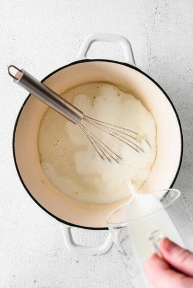 whisking milk into roux.