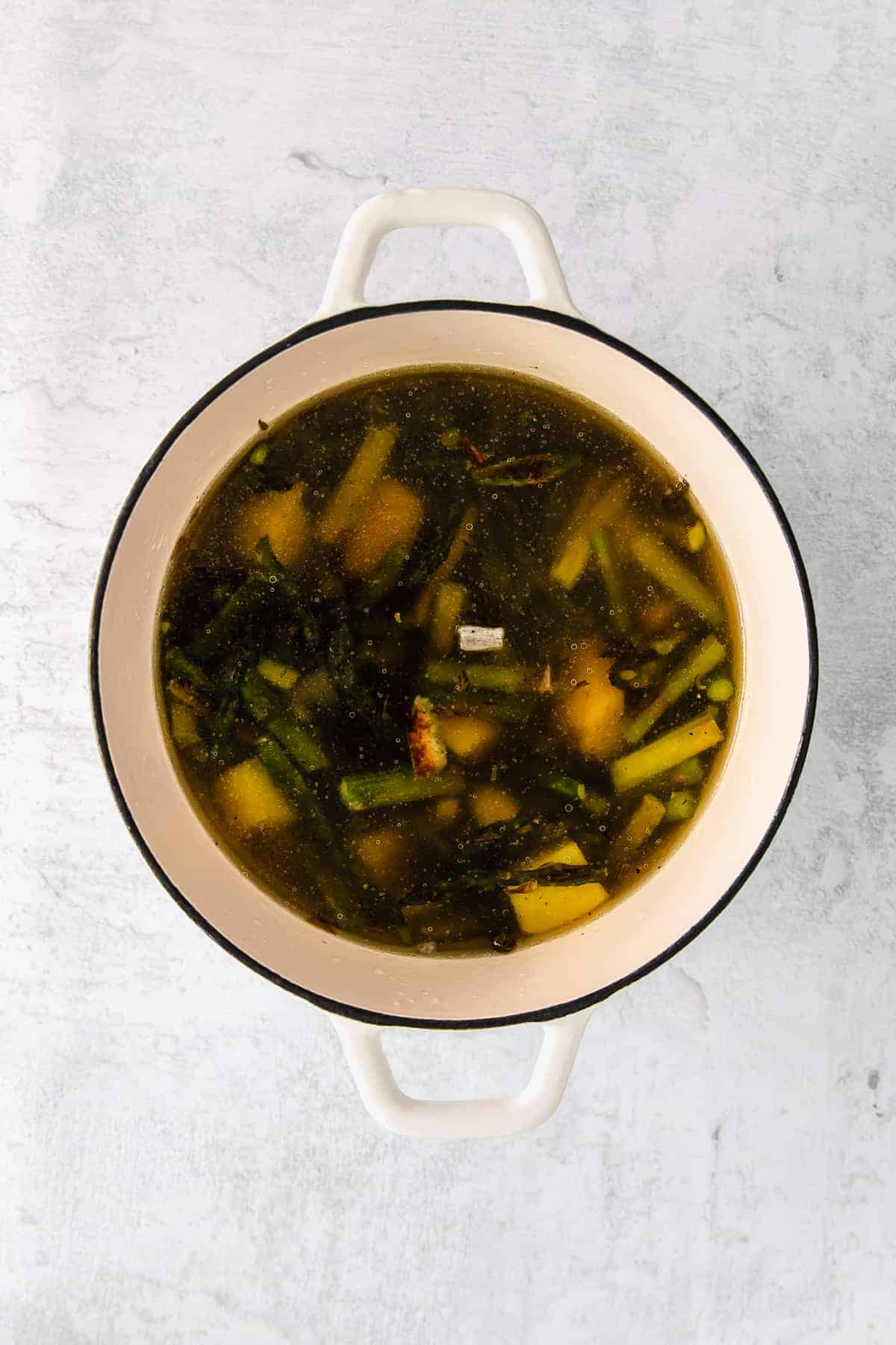 Veggies and broth in Dutch oven.