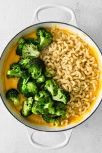 macaroni and broccoli in a pan on a white background.