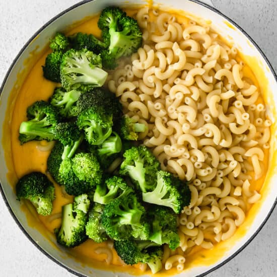 macaroni and broccoli in a pan on a white background.