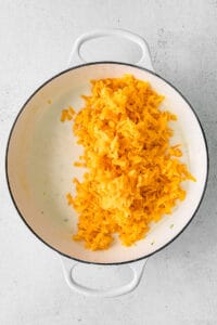 cheesy rice in a pan on a white background.