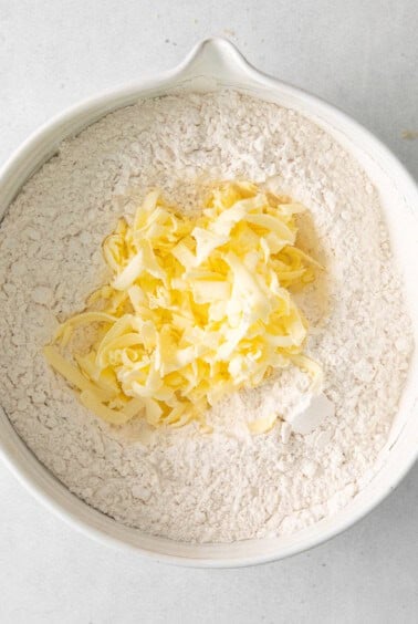 a bowl filled with flour and shredded cheese.