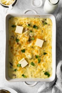 cheesy potato casserole in a white dish with parmesan cheese.