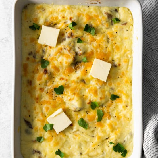 cheesy potato casserole in a white dish with parmesan cheese.