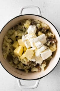 mashed potatoes and cheese in a pot on a white background.