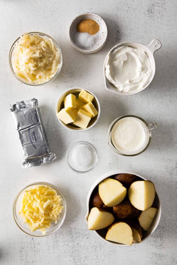 Cheese, butter, cream cheese, and other ingredients for cheesy mashed potatoes. 