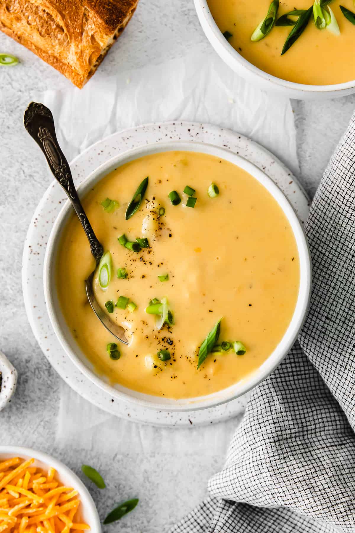 cheesy potato soup in a bowl with a spoon.