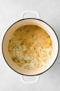 A cheesy potato soup in a white bowl.