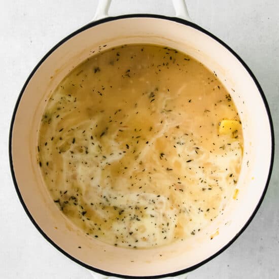 A cheesy potato soup in a white bowl.