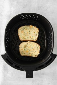 Two slices of Texas toast cooked in an air fryer.