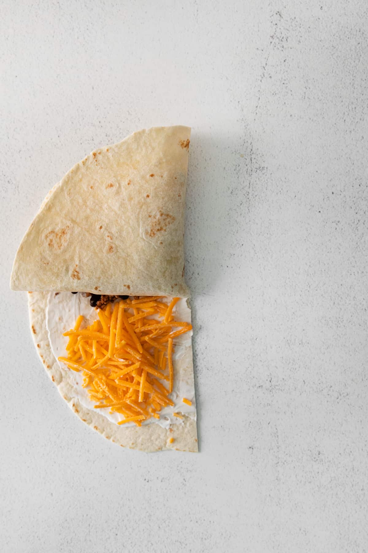 folding tortilla into quesadilla