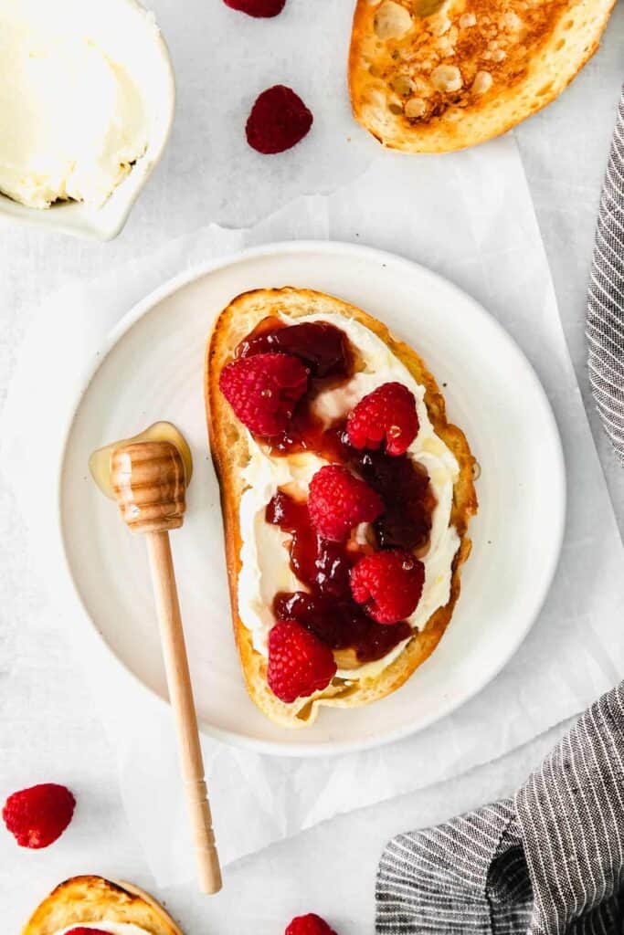 mascarpone toast with raspberries and raspberry preserves on the top of it