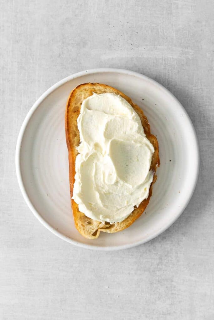 slice of sourdough toast with mascarpone spread on the top of it