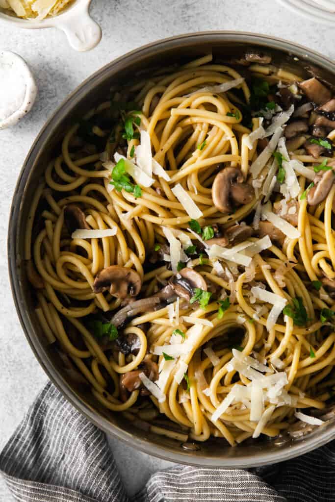 mushroom pasta in a skillet topped with parmesan cheese