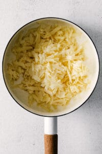 adding cheese to pot.