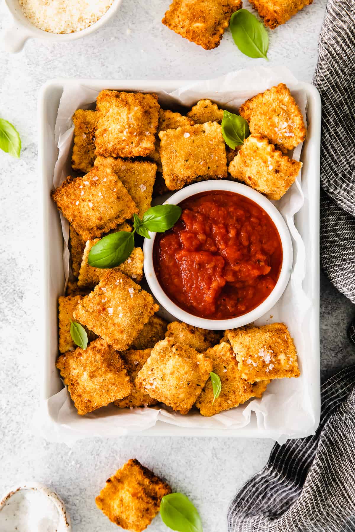 Air fryer ravioli served next to marinara sauce. 