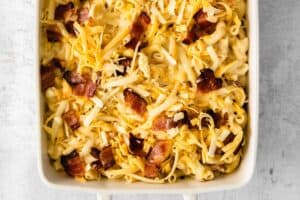 macaroni and cheese with bacon in a white baking dish.