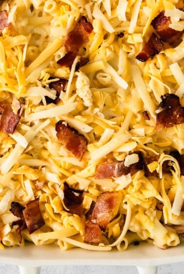 macaroni and cheese with bacon in a white baking dish.