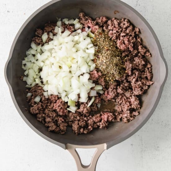 ground beef and onions in a frying pan.