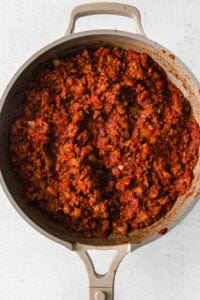 a pan full of meat in a skillet on a white background.