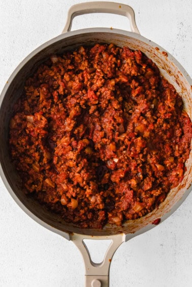 a pan full of meat in a skillet on a white background.