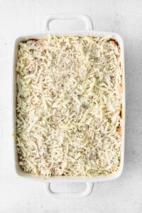 a casserole dish filled with cheese and pasta.