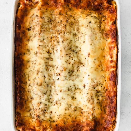 lasagna in a white dish on a white background.