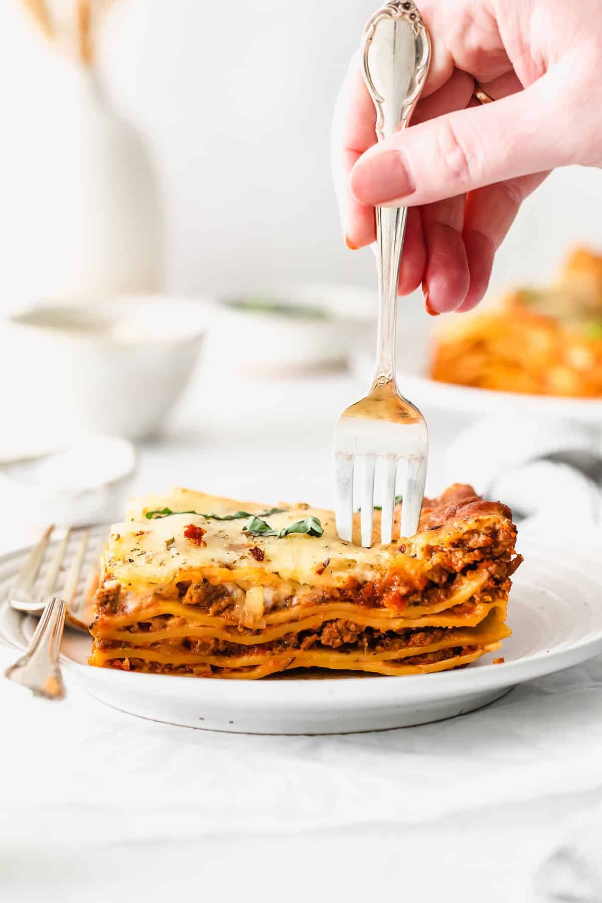 Slice of bechamel lasagna on a fork.