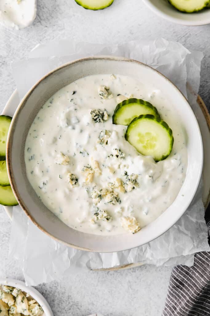 blue cheese dip and dressing in a bowl with cucumber slices