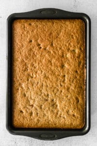 banana bread in a baking pan on a white surface.