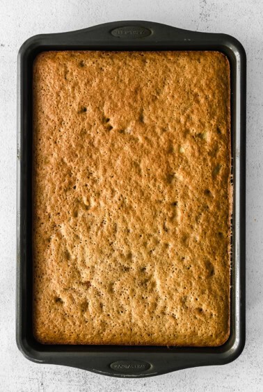 banana bread in a baking pan on a white surface.