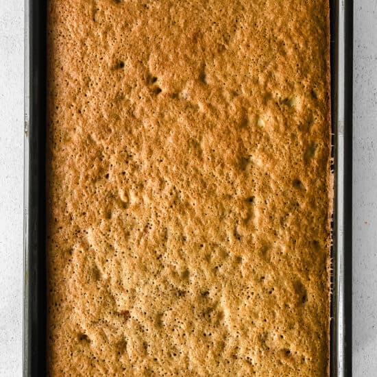 banana bread in a baking pan on a white surface.