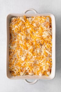 a casserole dish filled with cheesy enchiladas.