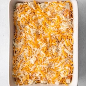 a casserole dish filled with cheesy enchiladas.