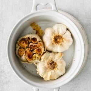 garlic in a white bowl on a white background.