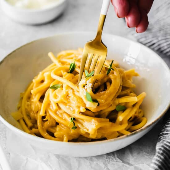A fork spinning garlic parmesan pasta.