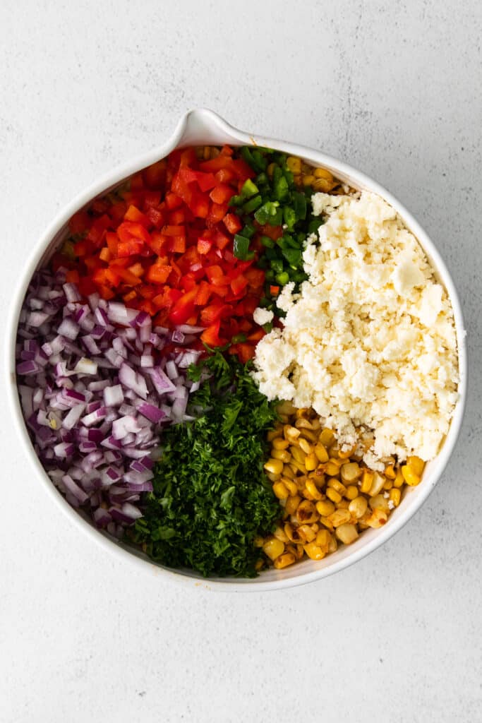 Mexican corn salad ingredients in a bowl.