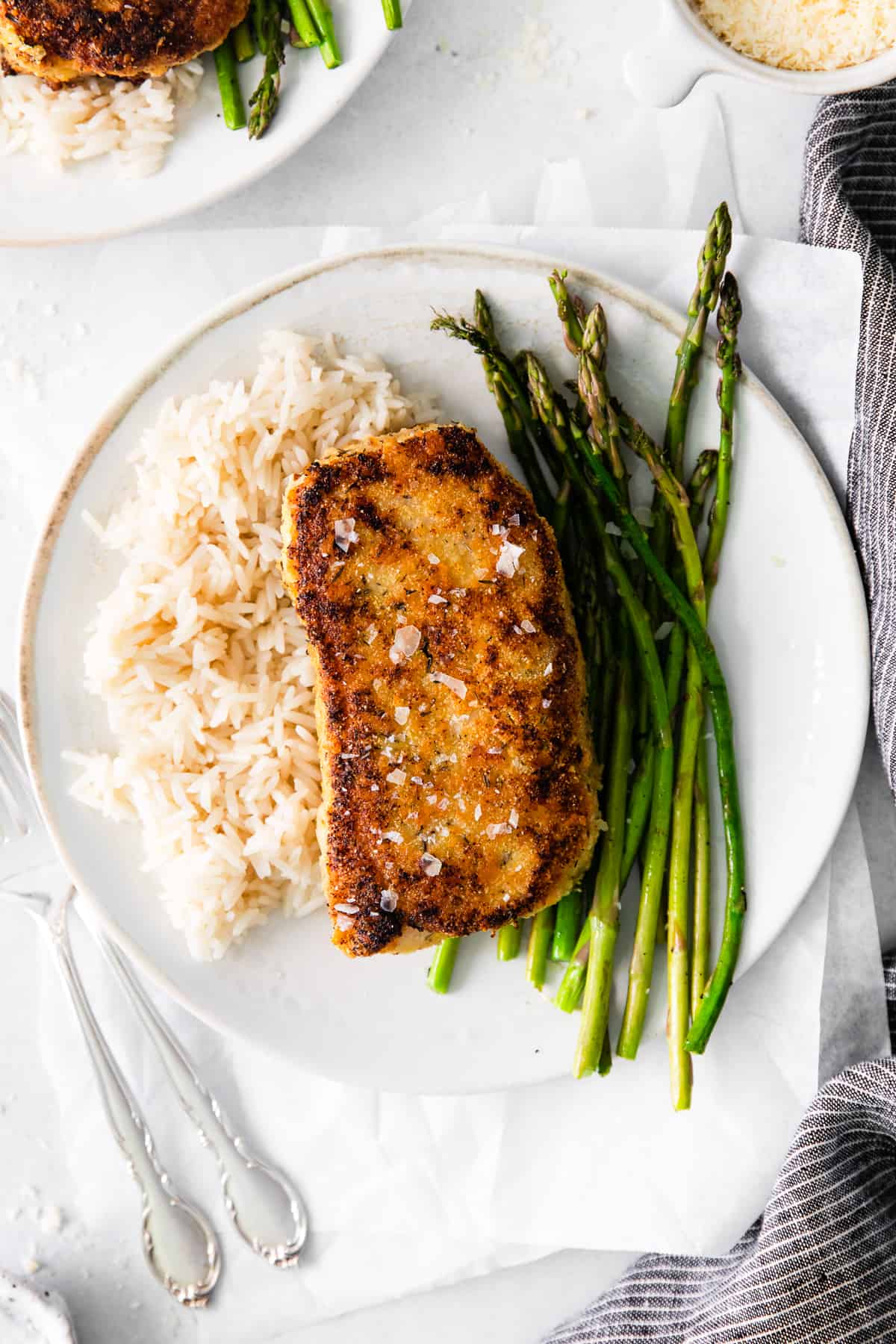 Pork chop on a plate with asparagus and rice. 