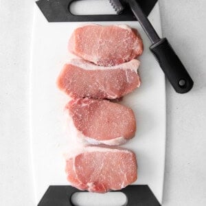 Pork chops on a cutting board.