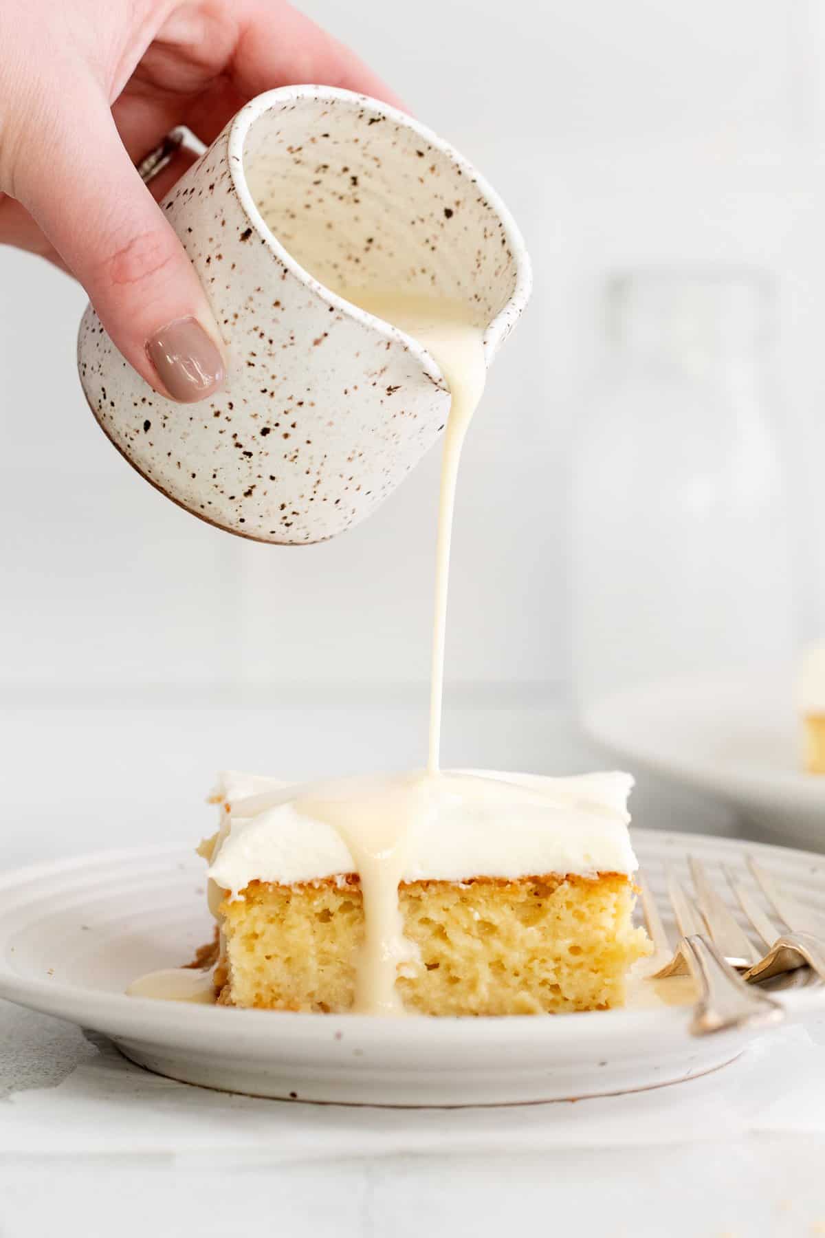 pouring leches on top of cake.