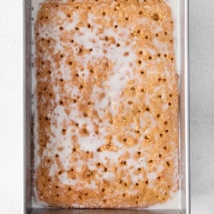 a graham cracker in a metal pan with icing.