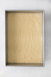 a metal pan with a yellow batter in it.