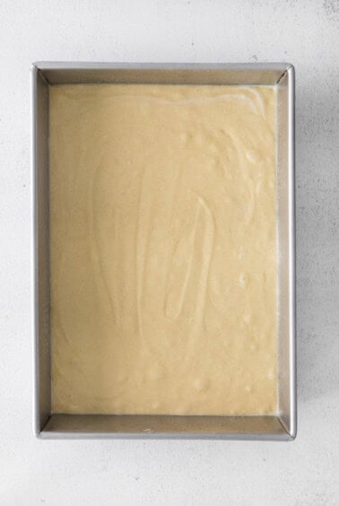 a metal pan with a yellow batter in it.